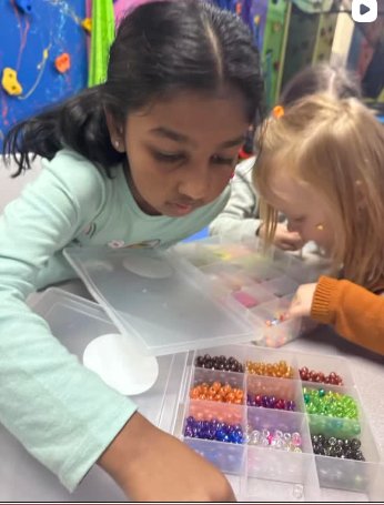 Kids working on a beading activity at TOTville.
